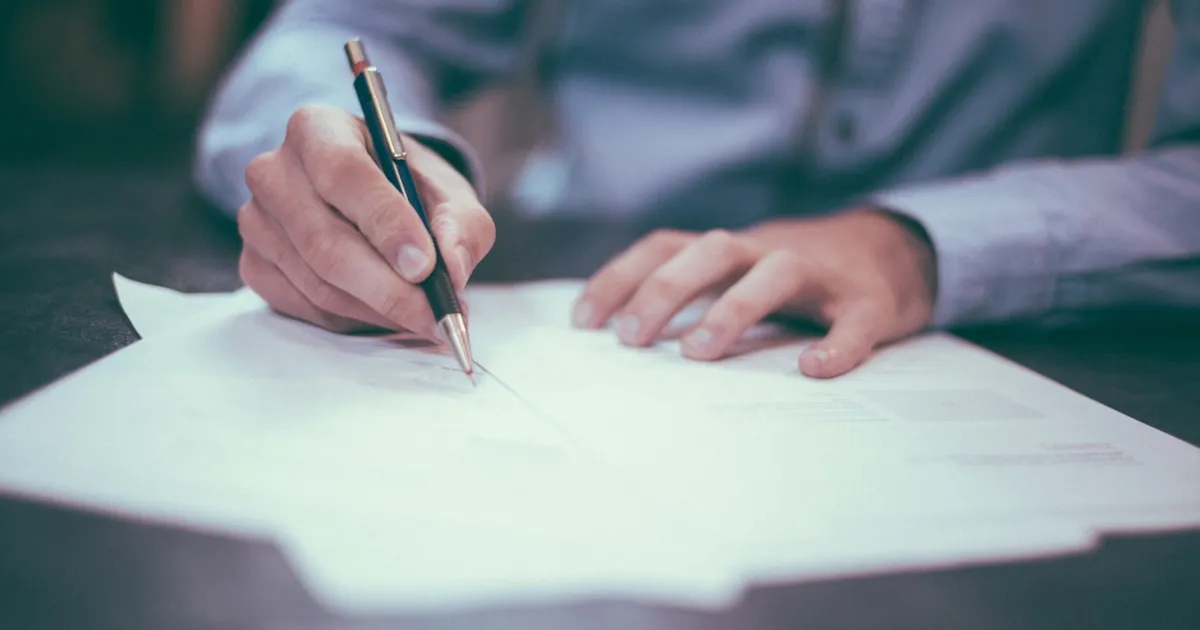 Documento de testamento sobre escritorio de notaría con pluma y sello